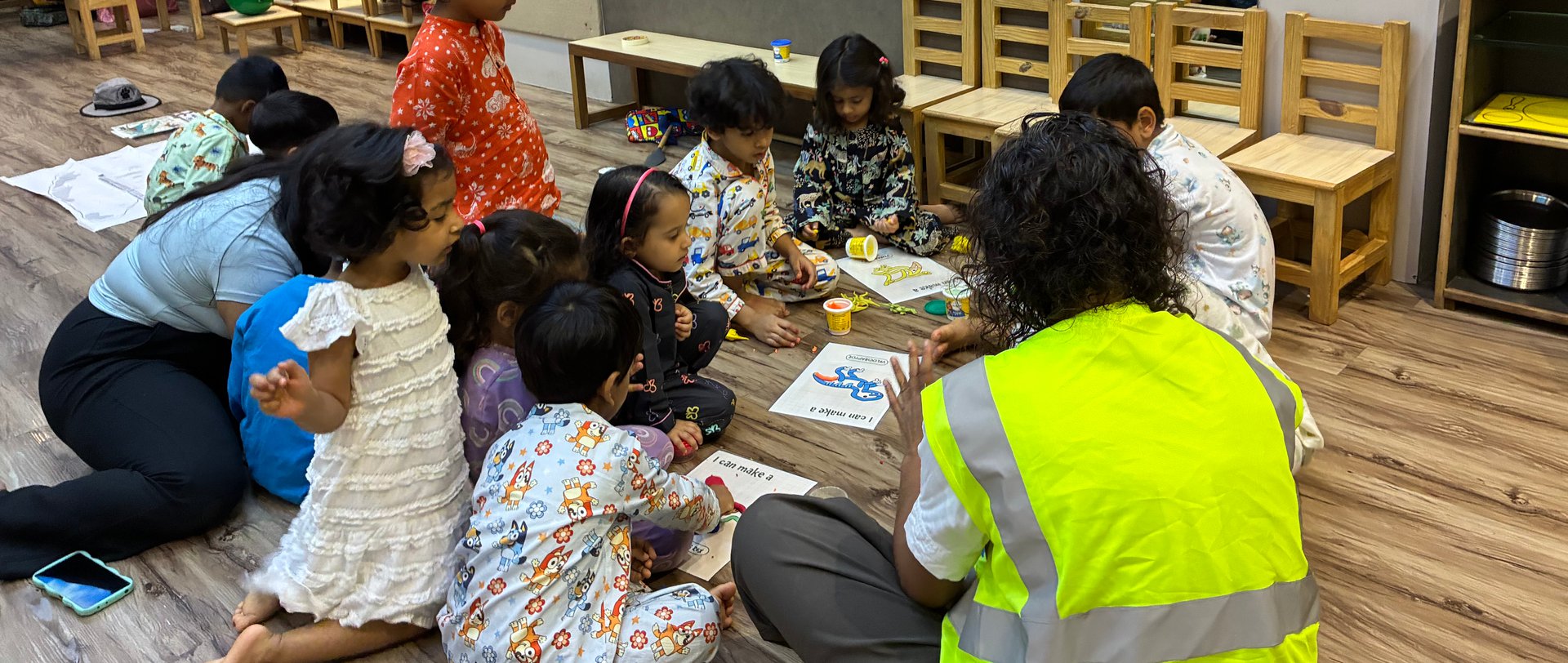 Children building with clay and cardboard on the floor during an early Owtofbox session
