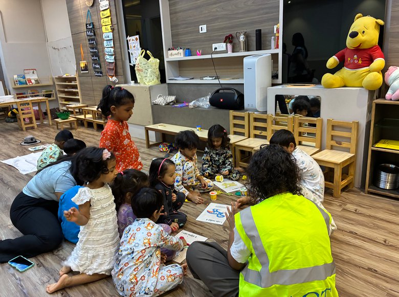 Children building with clay and cardboard on the floor during an early Owtofbox session