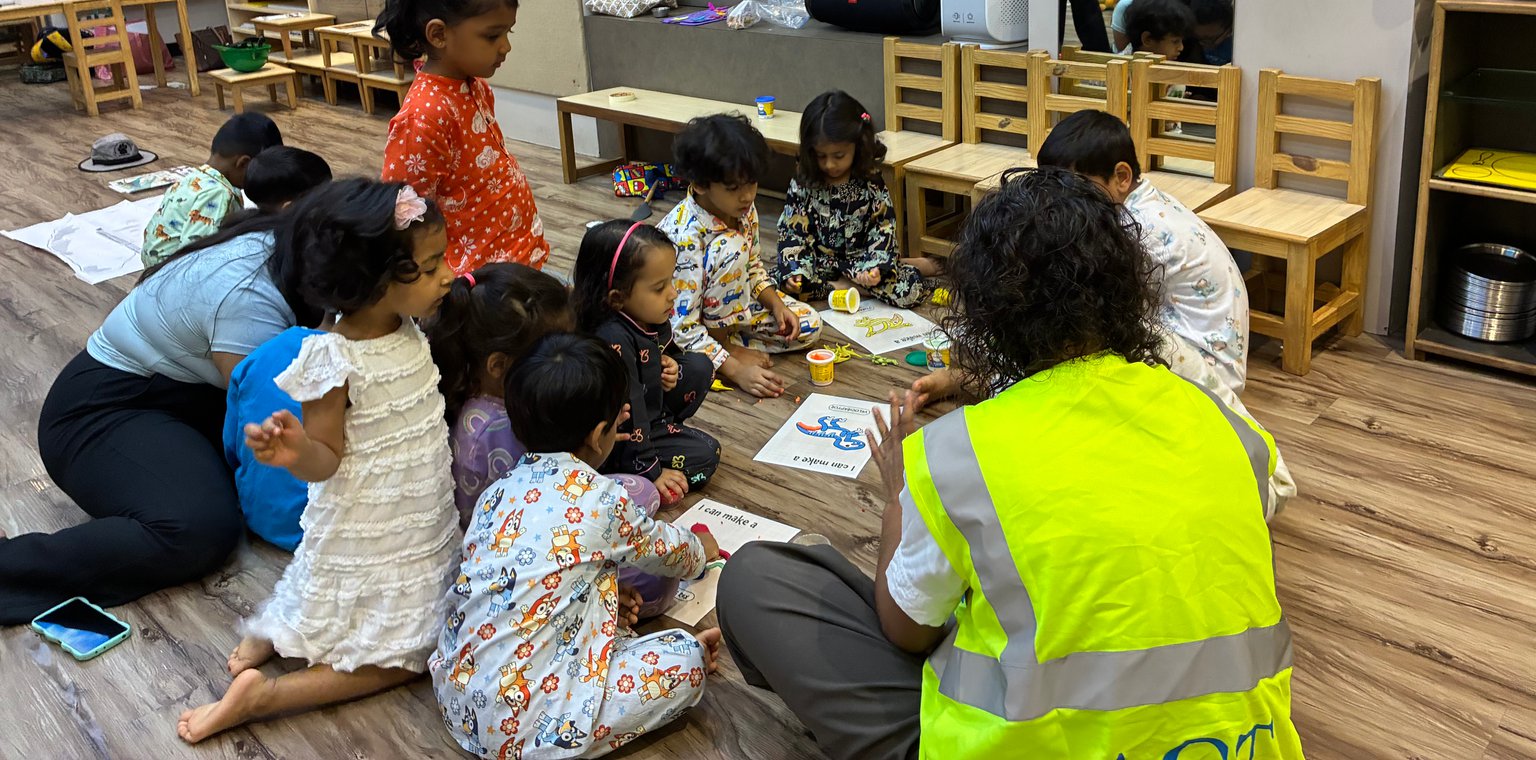 Children building with clay and cardboard on the floor during an early Owtofbox session