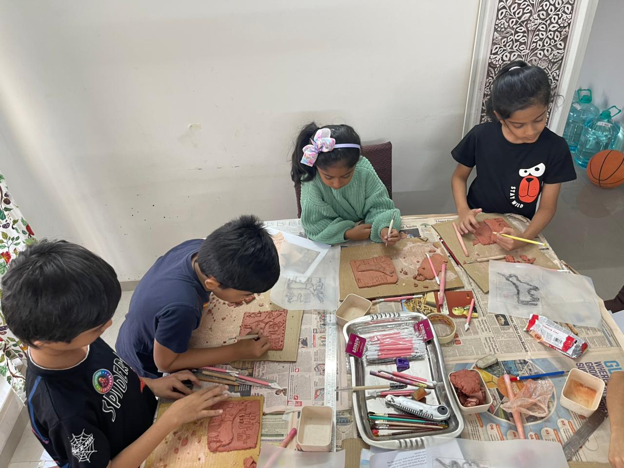 Kids at an Owtofbox in-person workshop building with real materials